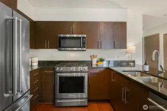 Spacious kitchen with gas range, abundance of cabinets, stainless appliances, and breakfast bar.