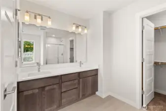 Primary bath features a dual vanity with quartz counters and undermount sinks.