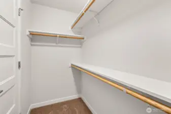 Primary walk-in closet with solid shelving.