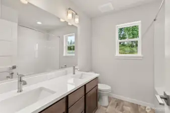 Upstairs hall bath features a dual vanity with quartz counters and undermount sinks.