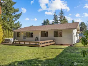 The expansive backyard offers a fully fenced sanctuary with a garden shed, dog run, lush grassy areas, and multiple decks perfect for barbecues and outdoor gatherings.