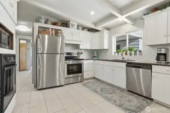 Updated kitchen with tile floors, stainless appliances, eating bar and opens to family room, living room and dining room - virtually staged photo