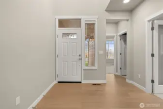 Entryway looking back at entry door with decorative glass panels that allow natural light to shine through!