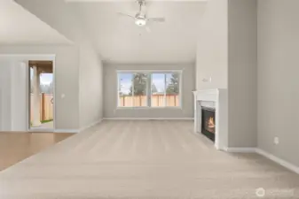 9’ ceilings and wood wrapped windows on main floor. Living room with plenty of natural light featuring cozy gas fireplace with tile surround and ceiling fan.