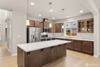 Kitchen features sable-stained Maple Cabinets and Quartz countertops with tile backsplash. Whirlpool stainless steel gas double oven is standard. This home also includes a refrigerator!