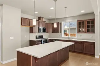 Kitchen features sable-stained Maple Cabinets and Quartz countertops with tile backsplash. Whirlpool stainless steel gas double oven is standard.