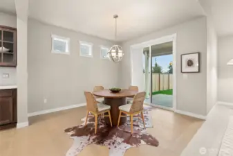Dining area features hardwood flooring and a glass slider that opens to backyard and patio area.