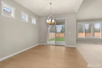Dining area features hardwood flooring and a glass slider that opens to backyard and patio area.