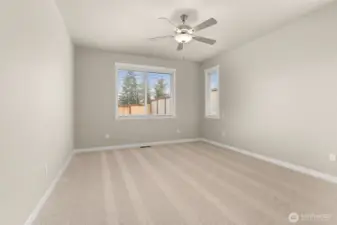 Inviting and spacious primary bedroom with ceiling fan for added comfort.