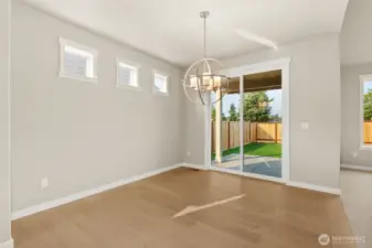 Dining area features hardwood flooring and a glass slider that opens to backyard and patio area.