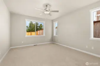 Inviting and spacious primary bedroom with ceiling fan for added comfort.