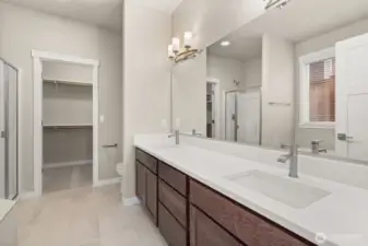 Primary bathroom comes with a standard separate walk-in shower with glass door, double vanity with undermount dual sinks, tile floor, quartz countertops.