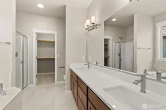 Primary bathroom comes with a standard separate walk-in shower with glass door, double vanity with undermount dual sinks, tile floor, quartz countertops.