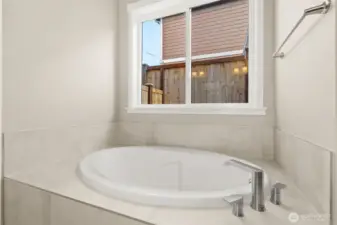 Soaking tub with tile surround.
