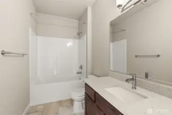 Full bathroom with undermount sink in Sable-stained Maple cabinet, quartz countertop with backsplash and tub/shower.