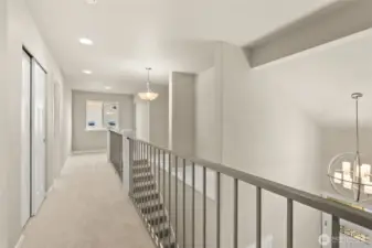 Bright and open upstairs hallway featuring modern metal railing with a view overlooking the main level.