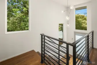 Front entrance to home framed with large windows and custom metal railings.