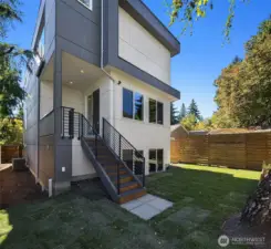 Fully fenced yard featuring covered deck off of kitchen.
