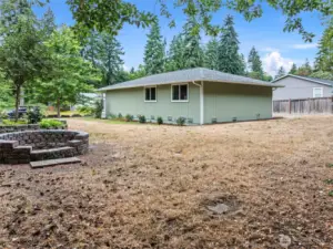 Spacious, nearly half-acre flat lot with room for RV parking, gardening, and entertaining around the fire pit.