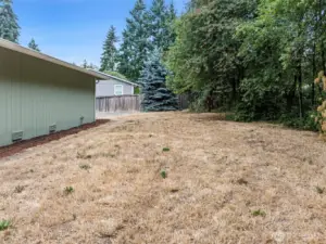 Spacious, nearly half-acre flat lot with room for RV parking, gardening, and entertaining around the fire pit.