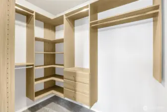 Efficient closet organizer system in primary walk-in closet.