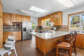 A stylish eat-in kitchen with stainless steel appliances, granite counters and breakfast bar.