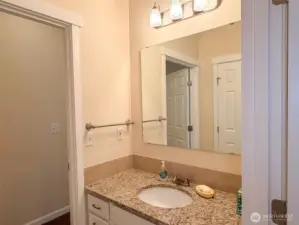 Lower countertop in accessible full bath with linen closet pictured in the mirror.