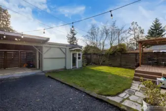 Lovely backyard with a deck, gas fire pit, storage room and office/workout space