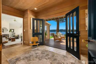 Warm and inviting entry with radiant heat, highlighted by French doors that open to the expansive deck, framing beautiful water views and enhancing the home’s connection to nature.