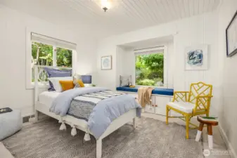 Bright secondary bedroom with abundant natural light and charming window seating.