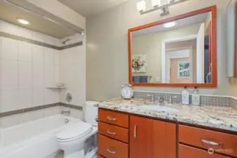 Main bath with beautiful cabinetry, tiled surround area and tiled flooring.  Great storage closet behind the door too!