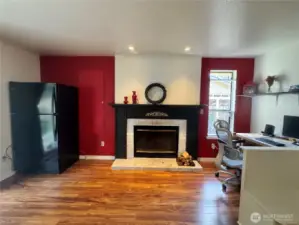 The family room with its wood burning stove, also has a Luxury Vinyl Planking floor. To your right is one of the seats of the dining nook.