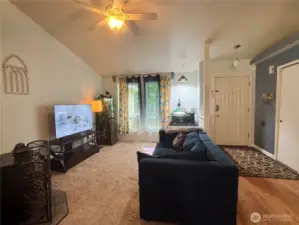 The living room features a wood pellet stove. It has a vaulted ceiling, and a ceiling fan.