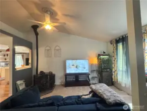 The living room has a ceiling fan, and is open to the kitchen and family room.