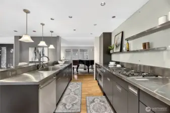 Gourmet kitchen with sleek cabinetry, stainless steel counters & gas range. Long workspace, ample storage & open flow make it ideal for cooking & entertaining.