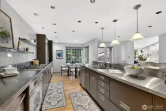 Chef’s kitchen with expansive counters, sleek cabinetry & gas range. Large island, pendant lighting & open flow create a stylish, functional space.