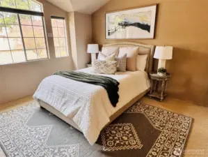 Spacious primary suite with vaulted ceilings, large windows & abundant natural light. Serene retreat with cozy sitting area & peaceful outlook.