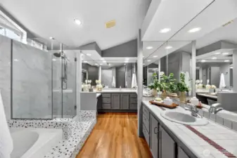 Spa-like primary bath with dual vanities, soaking tub & glass shower. Spacious layout, tile finishes & great lighting create a relaxing retreat.