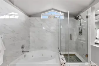 Luxurious bath with soaking tub & glass-enclosed shower. Elegant tilework, natural light & spacious design create a relaxing, spa-like experience.