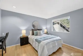 Bright & inviting second bedroom with hardwood floors, soft neutral tones & abundant natural light. Well-proportioned layout offers flexibility for guests, home office or everyday comfort.