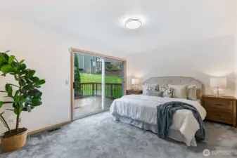 Primary bedroom on the main floor with a slider out to an oversized deck and park-like landscaping.