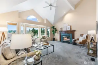 Living room with vaulted ceilings, lot of windows, gas fireplace and updated carpet.