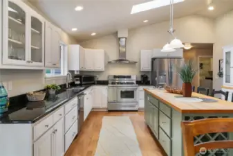 The chef’s kitchen is bathed in natural light, with abundant skylights and windows filling the space with sunlight.