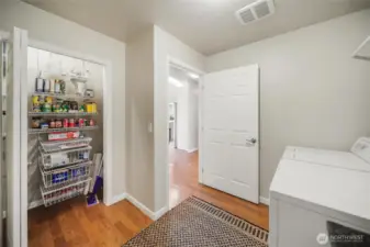 Spacious pantry is located in the utility room just off the kitchen.