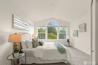 Primary bedroom with vaulted ceiling.