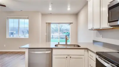 Kitchen with stainless appliances and sliding door access to the backyard.