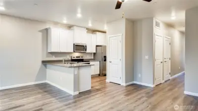Spacious open concept layout with modern kitchen, large peninsula, and durable flooring throughout.