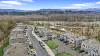 Aerial view of a quiet street backed by river and mountain views.