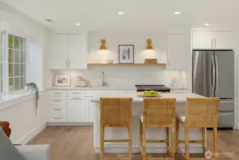 Circa lighting sets the tone for the well appointed kitchen with range/stove and refrigerator.