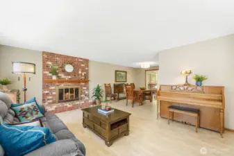 Expansive living room with wood burning fireplace, laminate flooring and updated lighting. Newly repainted!
